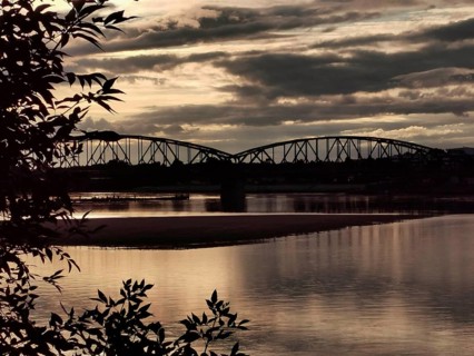 Landscape with a bridge in the background at sunset with dramatic clouds