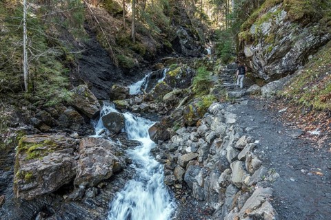 Female hiker on the hiking trail in Gaissalptobel with Gaissalpbach, Reichenbach, Oberstdorf,