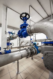 Large industrial pipe systems with blue valve and grey base, ENCW Netze Calw waterworks, Calw,