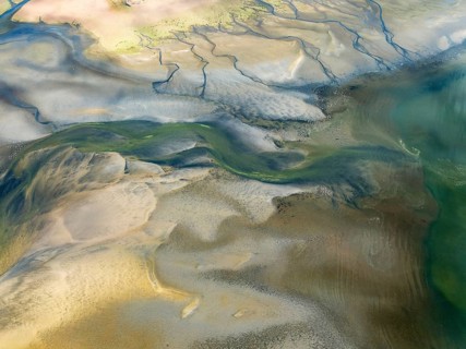 Streams and marshes at low tide in the coastal wetlands of the Walvis Bay lagoon. In the distance