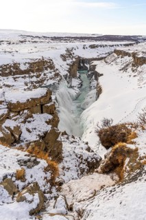Beautiful snowy Gullfoss waterfall in the cold Icelandic winter without people, vertical photo