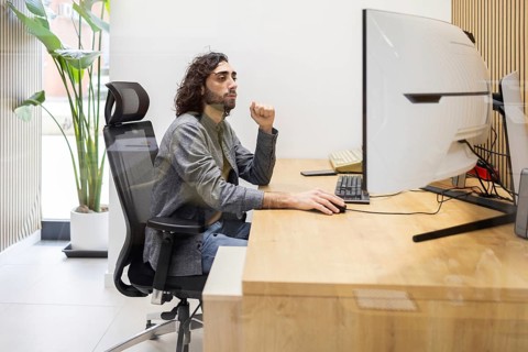 A man working diligently at a sleek workstation, showcasing focused concentration. The contemporary