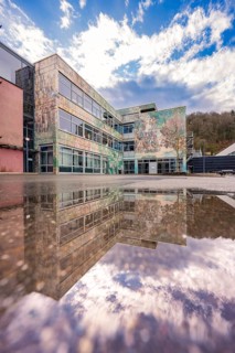 Modern building reflected in a water surface under a dramatic sky, Nagold, Calw district, Germany