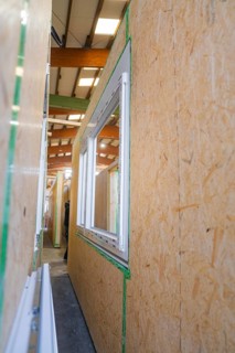 Close-up of a window that has not yet been installed in a wooden structure, façade construction in