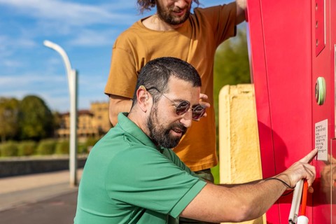 A visually impaired man receives assistance from a friend, highlighting trust and cooperation They