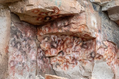 Colored hands at the wall of the canyon, Cueva de las Manos, prehistoric paintings, Unesco world