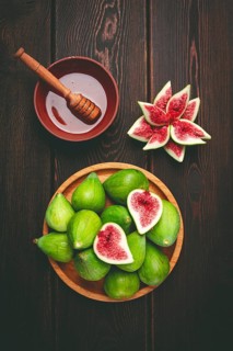 Fresh green figs, honey, top view, on a wooden table, no people