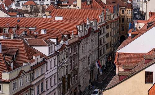 Scenic bird's-eye view of densely packed red rooftops in Prague's historic center, showcasing