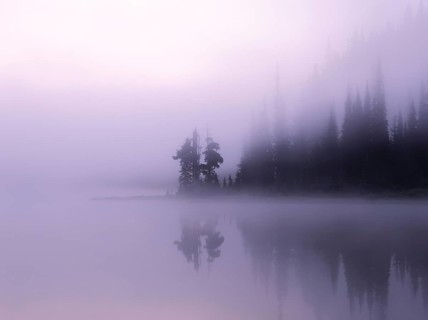 An ethereal mist covers Reflection Lake at Mount Rainier National Park, creating a serene view with