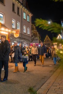 Visitors stroll through the illuminated Christmas market, enjoy the wintry atmosphere and festive