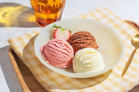 Delicious ice cream trio on a wooden tray with golden spoon, captured from a slightly high angle