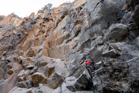 Two climbers tackles a challenging ascent on a rugged rock face, showcasing the adventurous spirit