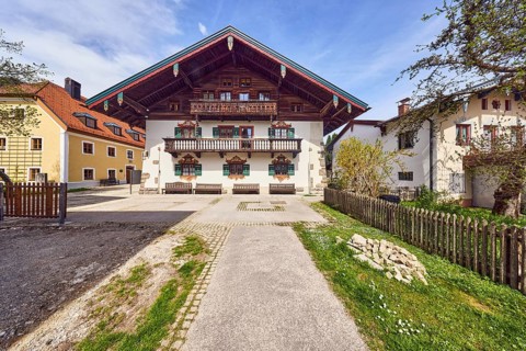 Town hall, alpine building, commercial building, balcony, façade with windows, shutters and