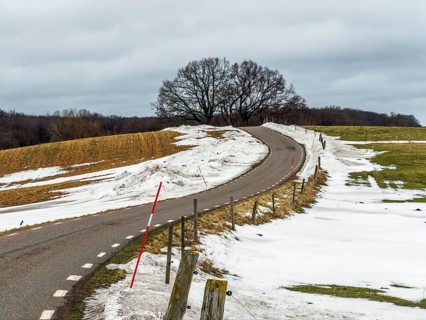 Winter, soon spring. Snowmelt. country road in landscape with melting snow in Ystad municipality,