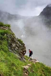 Mountaineers on a hiking trail, cloudy mountain landscape with Lower Arctic Sea glacier, Bernese