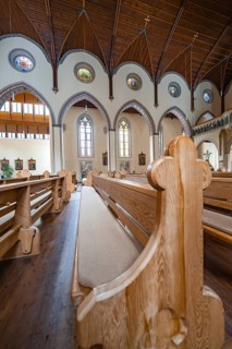 Interior view of a church with wooden benches and stained glass windows, Bad Wildbad, St
