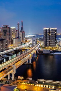 Kobe skyline from above with harbour and elevated roads at night in Kobe, Japan