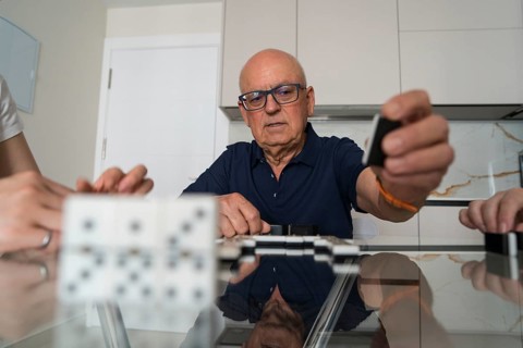 A family engages in a lively game of dominoes, fostering connection and enjoyment while gathered