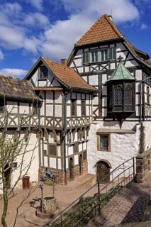 Inner courtyard with several half-timbered houses and a fountain, under a blue sky, Wartburg Castle