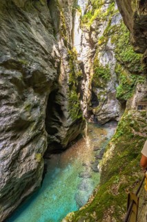 Turquoise water flowing between narrow rock walls at the bottom of tolmin gorges canyon in triglav