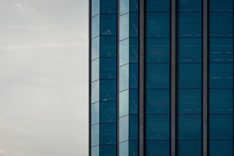 A striking image of a modern building featuring a blue glass facade, captured under a clear sky in