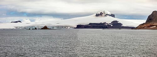 Vast ice fields and glaciers tower over the calm waters of the Antarctic Ocean, The coast and