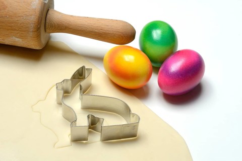 Rolled dough with bunny cookie cutter, rolling pin and Easter eggs