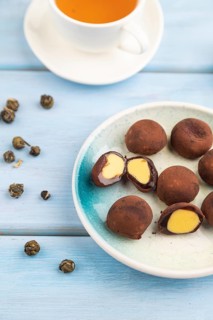 Japanese rice sweet buns chocolate mochi filled with cream and cup of green tea on blue wooden
