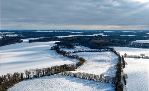 There is snow on the fields and lakes in the UNESCO Schaalsee Biosphere Reserve. aerial view.