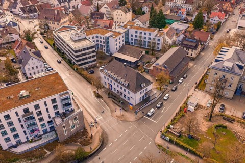 Urban scene with a central intersection and dense development, including various buildings, VHS