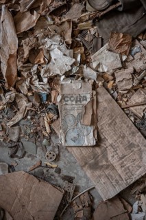 Rubbish and old instructions in Cyrillic script, abandoned destroyed room in a residential