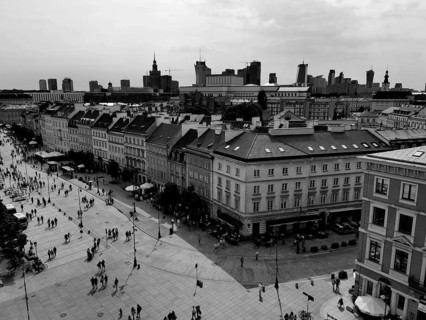 Urban scene in Warsaw with historic buildings, many people on the street and a modern skyline in