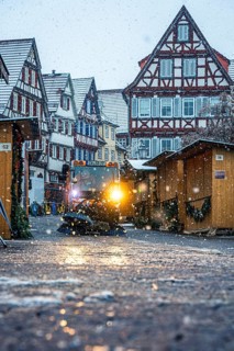 Christmas market in the snowfall with evening light illuminated by half-timbered houses, Black