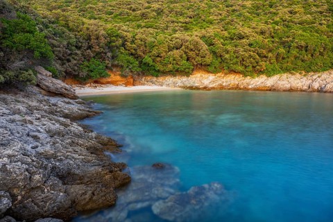 Crystal clear and turquoise water on the beach of Ustrine Bay on a sunny day at sunset on the