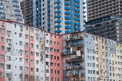 A vibrant cityscape showcasing a mix of modern and older high-rise buildings with colorful facades,