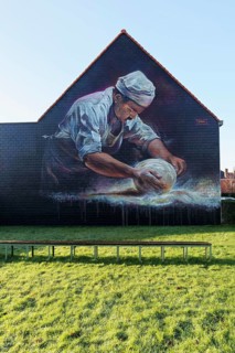 Mural, baker rolls loaf of bread in flour, baker's craft, mural by street artist SMOKE, Bruges,
