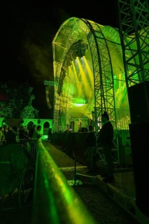 Person behind a barrier at a night concert in front of a green-lit stage, Klostersommer, Calw