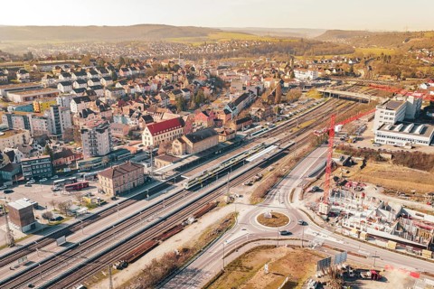 Urban development with construction cranes and railroad tracks, surrounded by residential