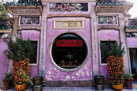 A colorful and culturally rich Taoist and Chinese Buddhist temple facade in Macau, adorned with