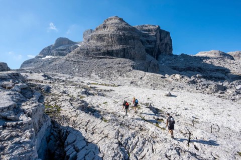 Three mountaineers on a hiking trail on the Grosté Plateau, Brenta Mountains, Parco Naturale