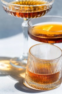 A close up of three elegant glasses filled with Georgian amber wine, showcasing its rich, golden