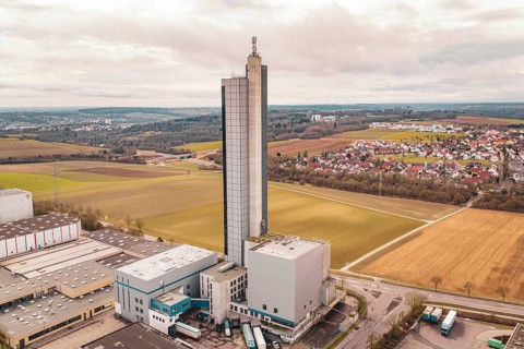 Industrial complex with tower surrounded by fields and villages under a cloudy sky, Schapfenmühle,