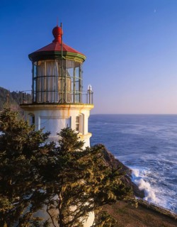 The Heceta Head Lighthouse stands majestically during dusk, its light casting a gentle glow over