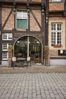 Entrance area of a restaurant in a historic half-timbered brick house with white, divided windows