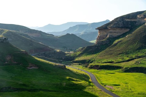 Road through grasslands with sandstone cliffs and cliffs, landscape in Golden Gate Highlands