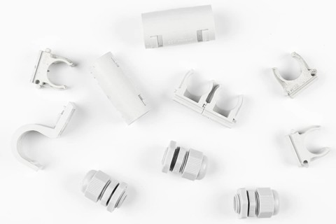 White plastic parts and cable clips on white background