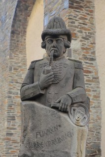Stone sculpture with pipe in mouth and inscription, spark fools fountain in memory and memorial of