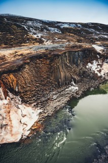 Stunning basalt columns along the turquoise river in Studlagil Canyon, Iceland. This breathtaking