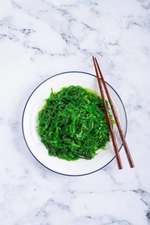 Chuka salad, made from fresh seaweed, with sesame dressing, served on a white plate, with