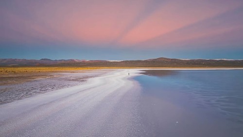 A stunning panoramic view of Salinas Grandes in Salta, Argentina. The salt flats reflect a